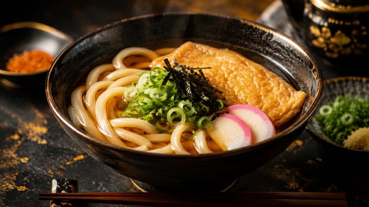 Autentisk japansk kake udon med kryddig dashi-buljong, kamaboko, nori och salladslök
