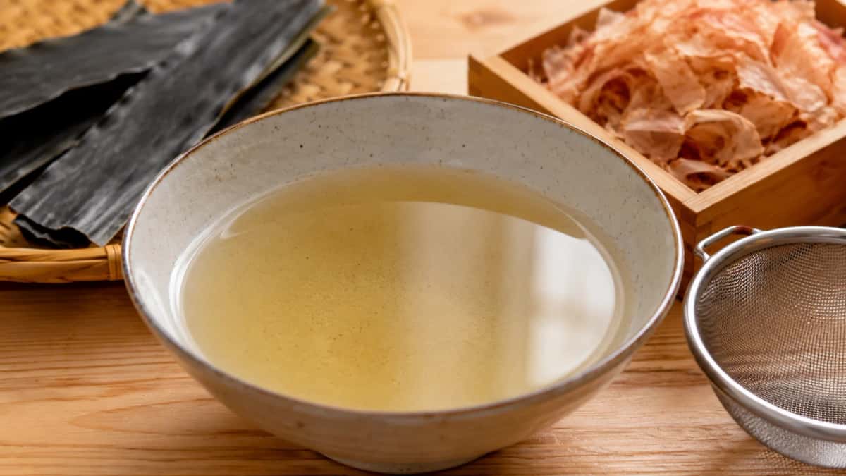 Klar japansk dashibuljong i skål med kombu och katsuobushi