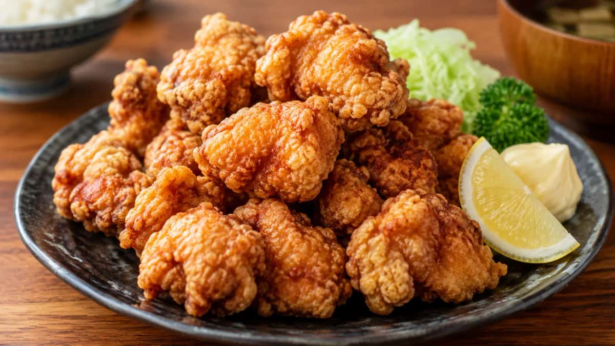 Japansk karaage krispigt friterad kyckling med potatisstärkelse serverad med citronklyftor och japansk majonnäs på izakaya