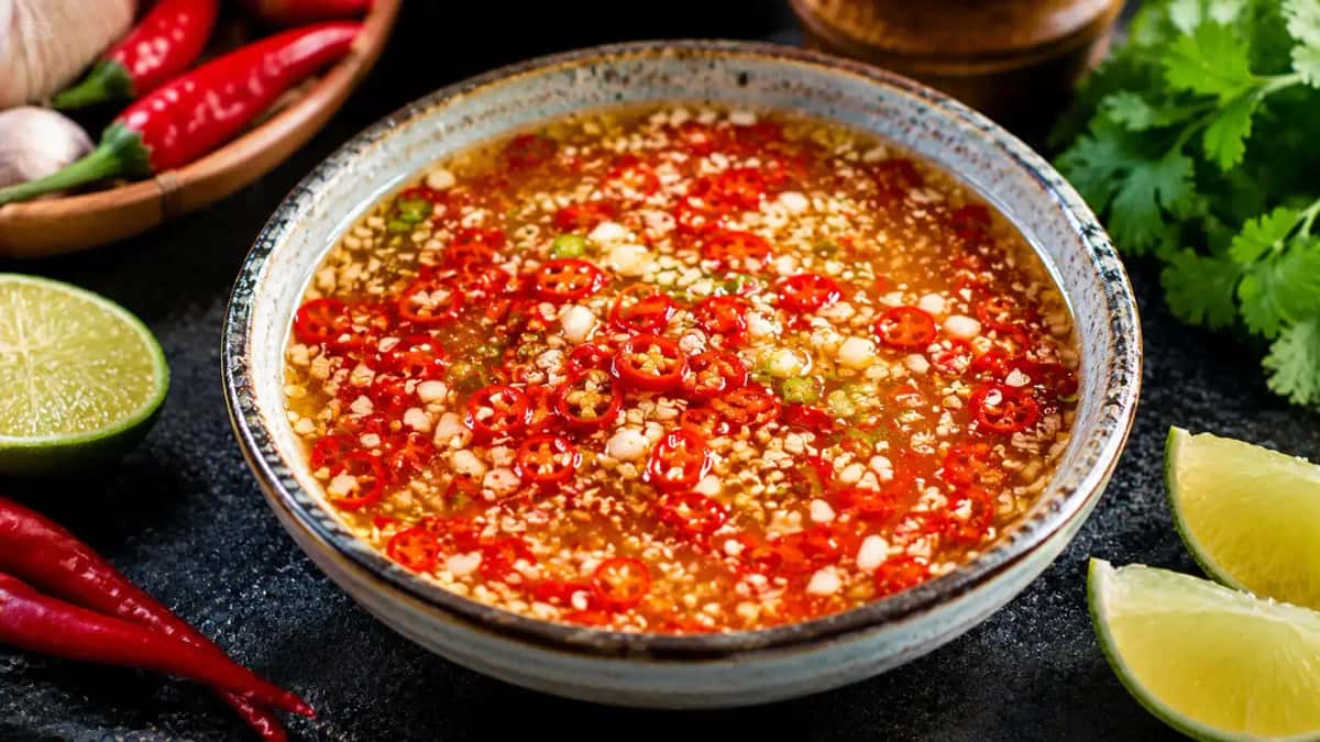 Vietnamesisk Nuoc Cham i liten skål med chili och vitlök, frisk limesås med röda chiliflingor